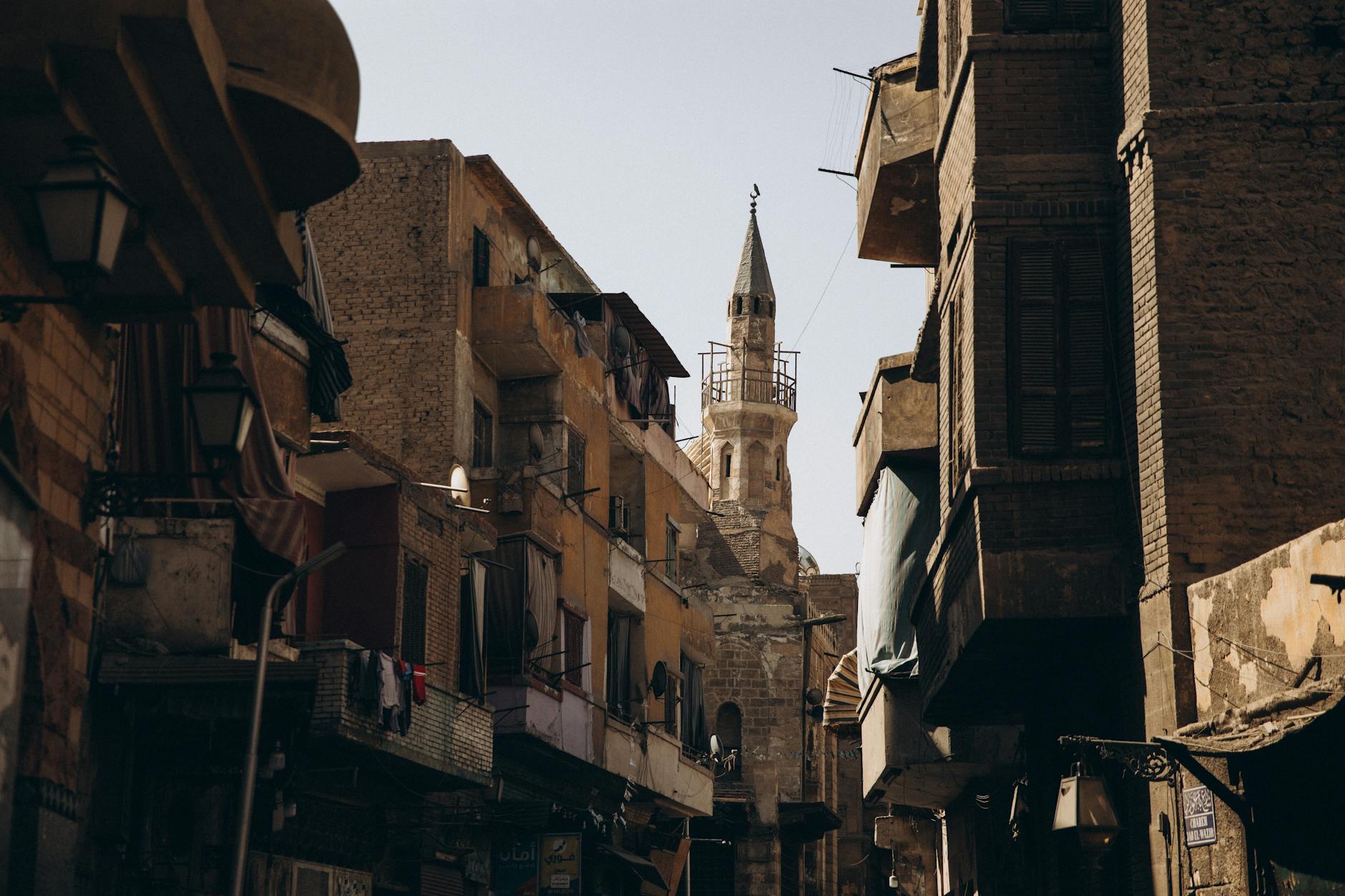 Narrow street in Cairo featuring historic Islamic architecture and urban life.