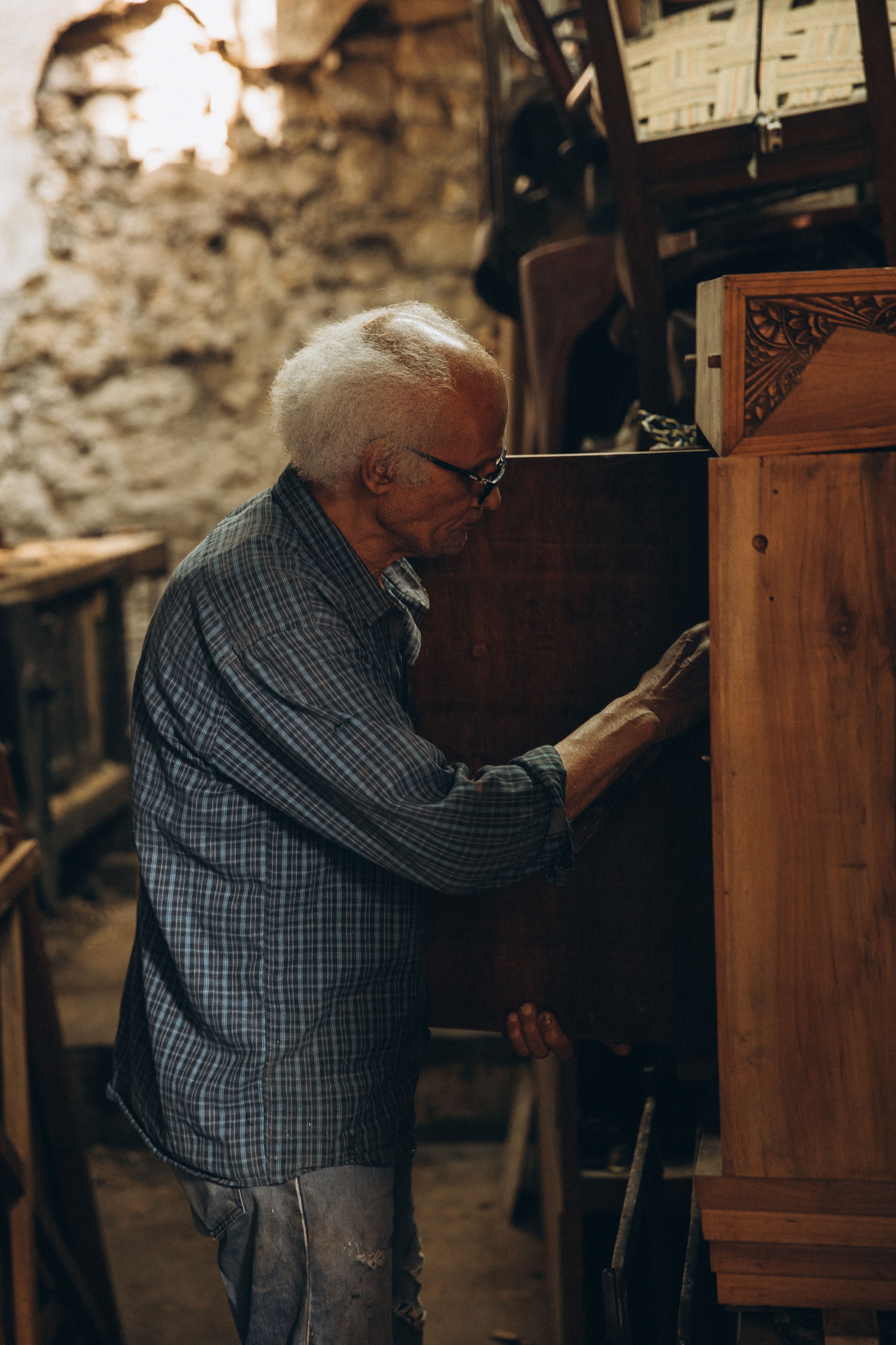 A skilled elderly carpenter works meticulously on a wooden piece in a Cairo workshop, showcasing traditional craftsmanship.