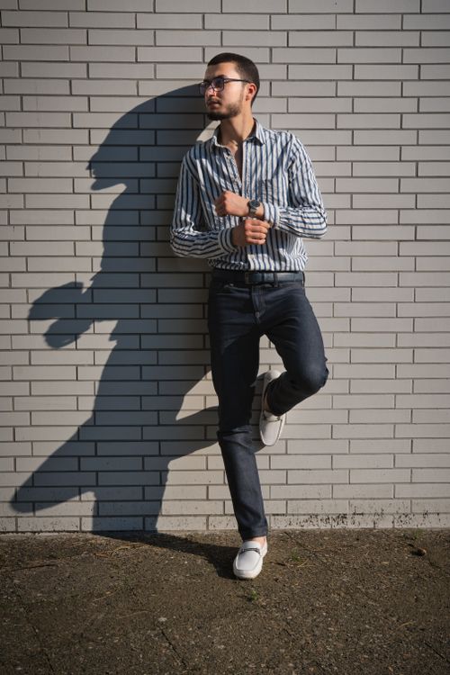 Free A fashionable young man poses confidently against a brick wall in Berlin, showcasing modern style. Stock Photo
