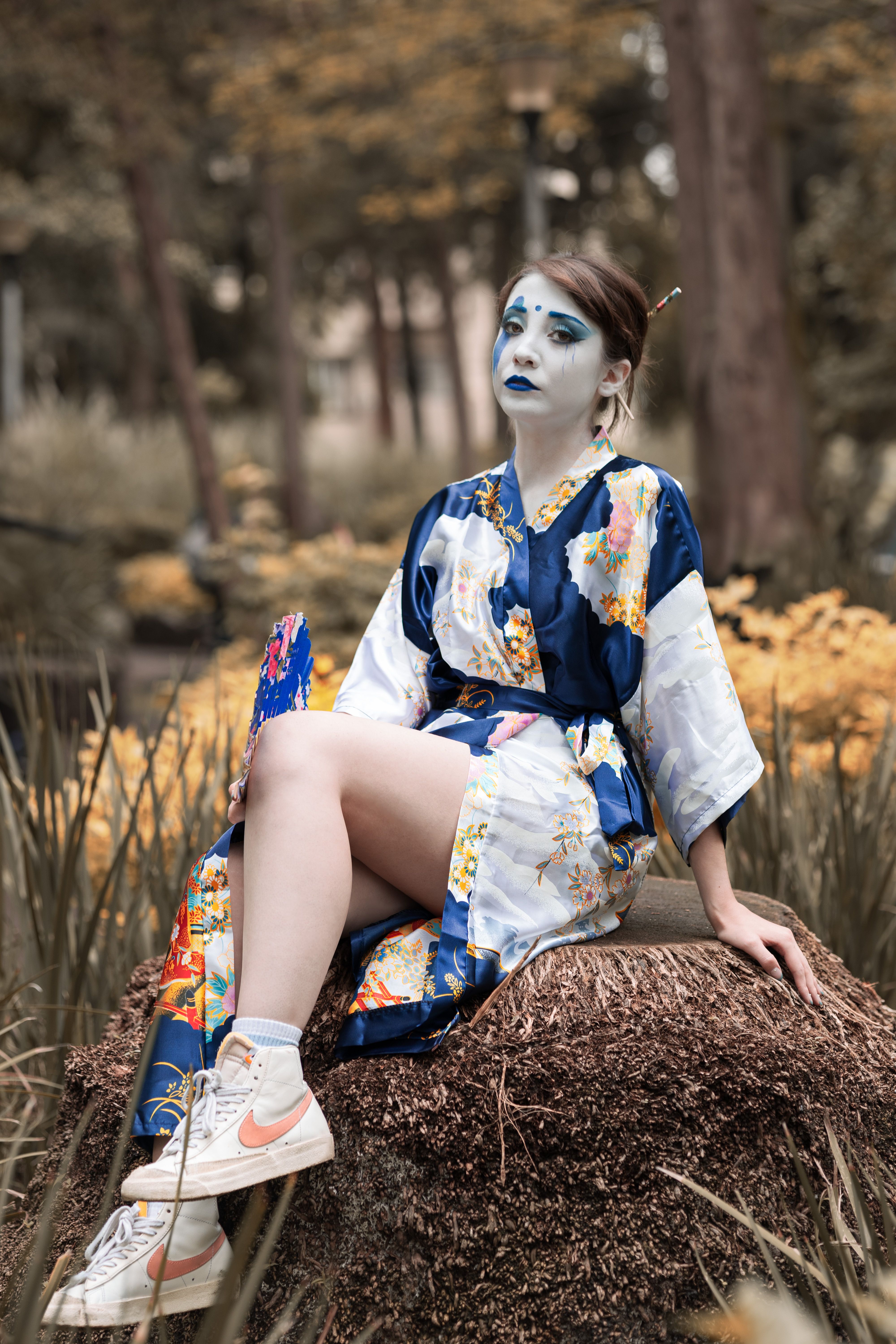 A woman in a blue and white outfit sitting on a rock · Free Stock Photo