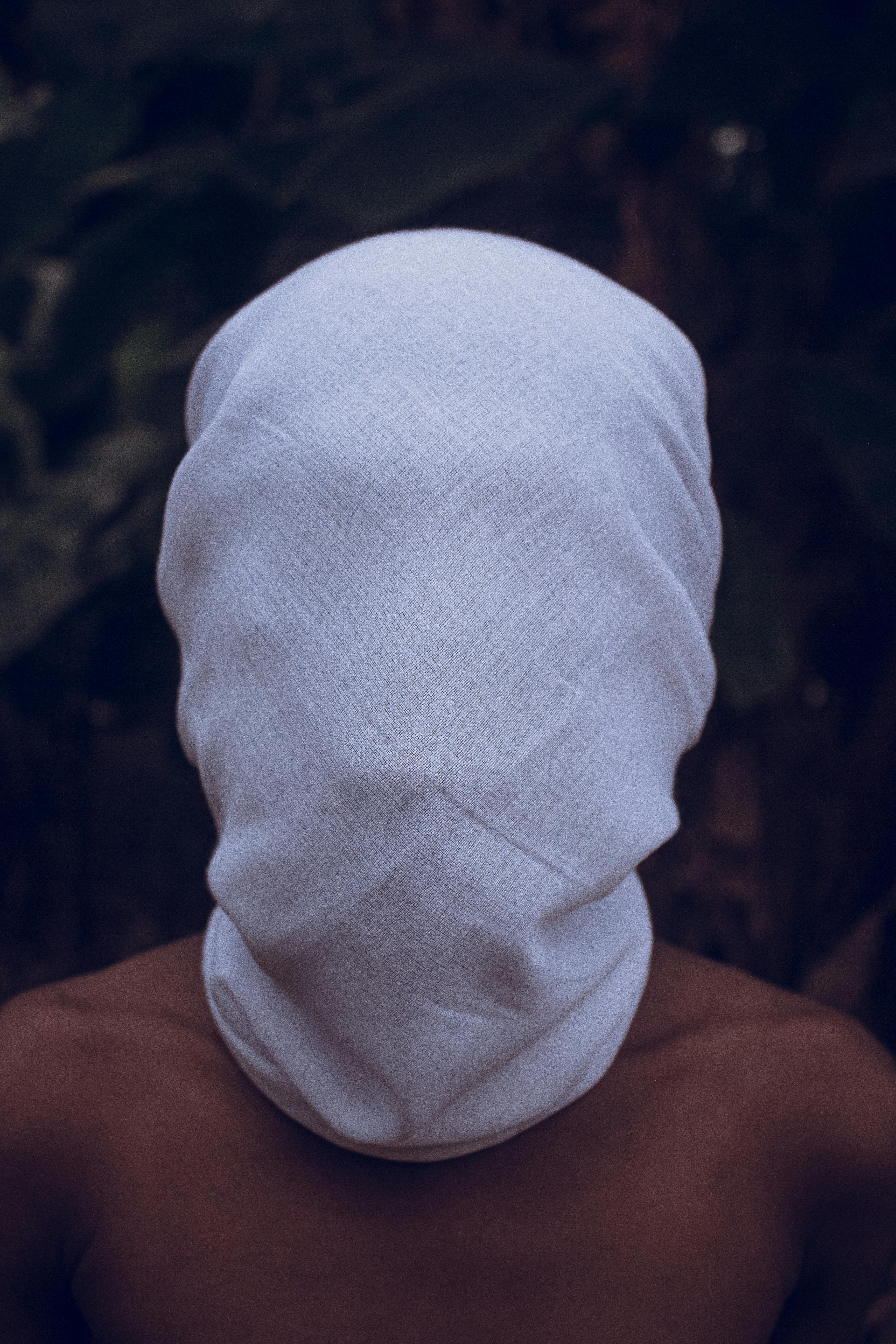 a person with a white cloth covering their face