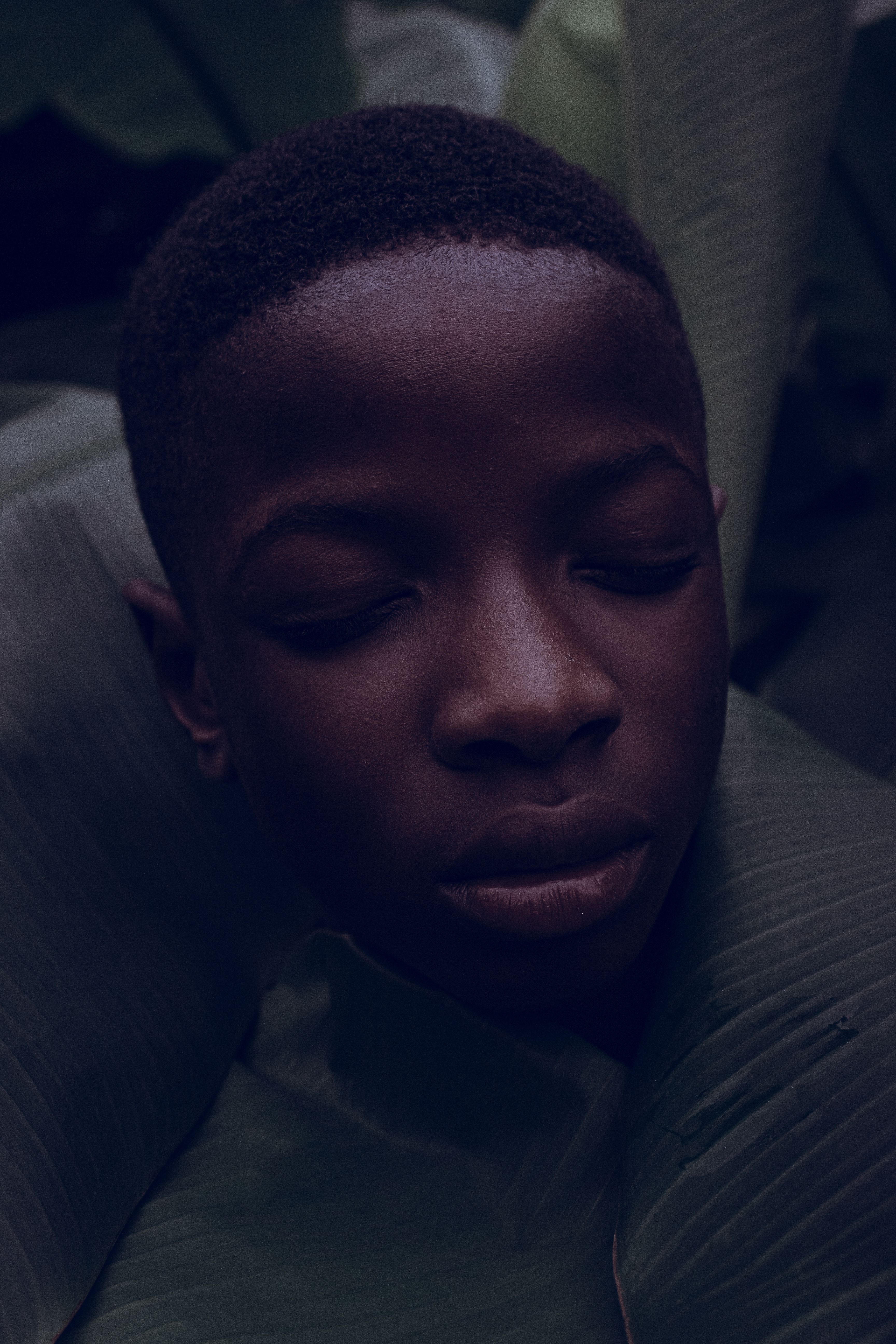 A young black boy with his eyes closed · Free Stock Photo