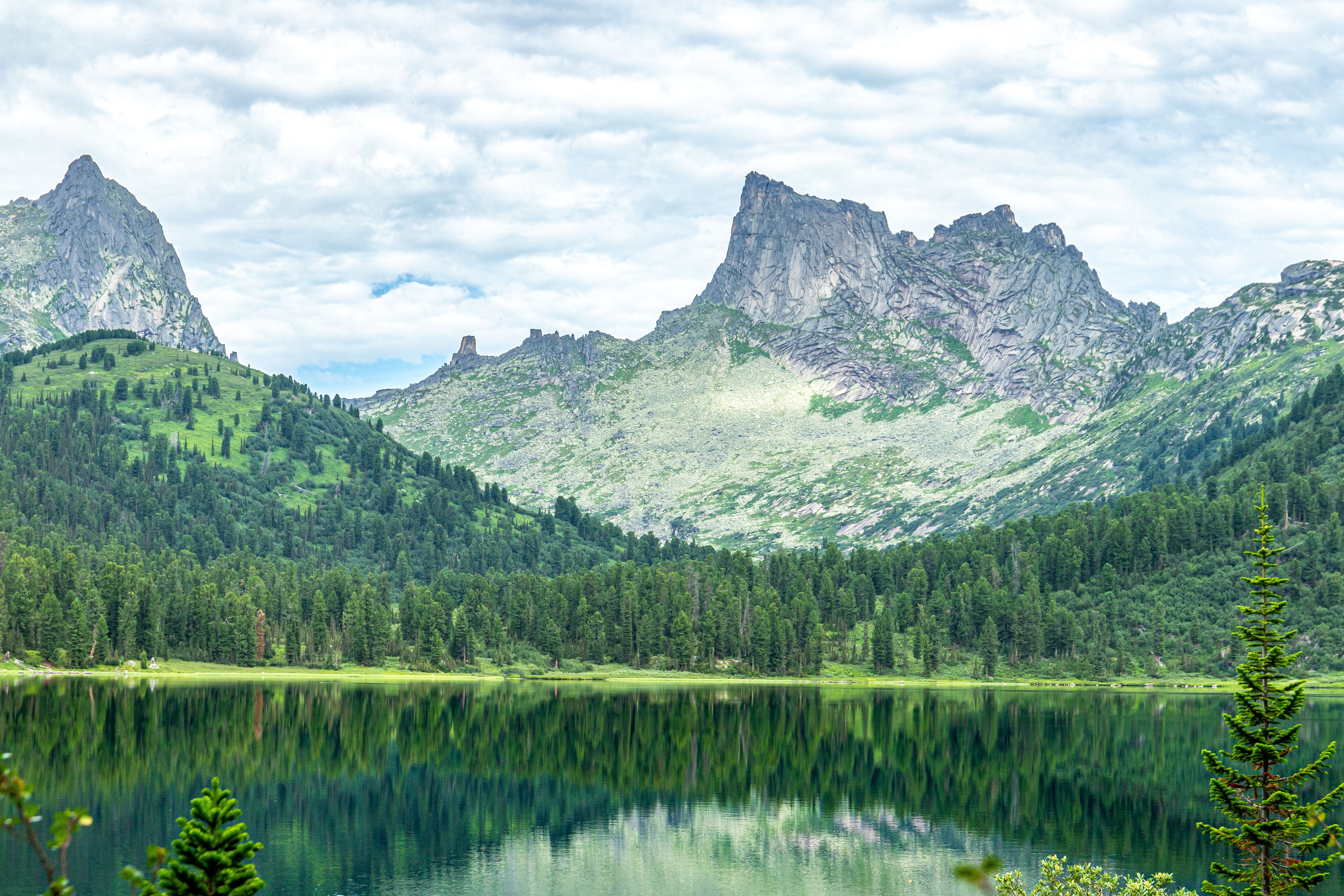A mountain lake surrounded by trees and mountains · Free Stock Photo