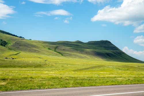 Free Vast green hills under a blue sky in Saragash, Khakassia, Russia. Stock Photo