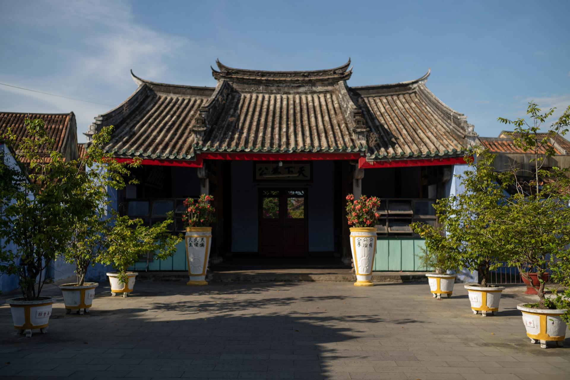 A chinese style building with two large pots on the roof