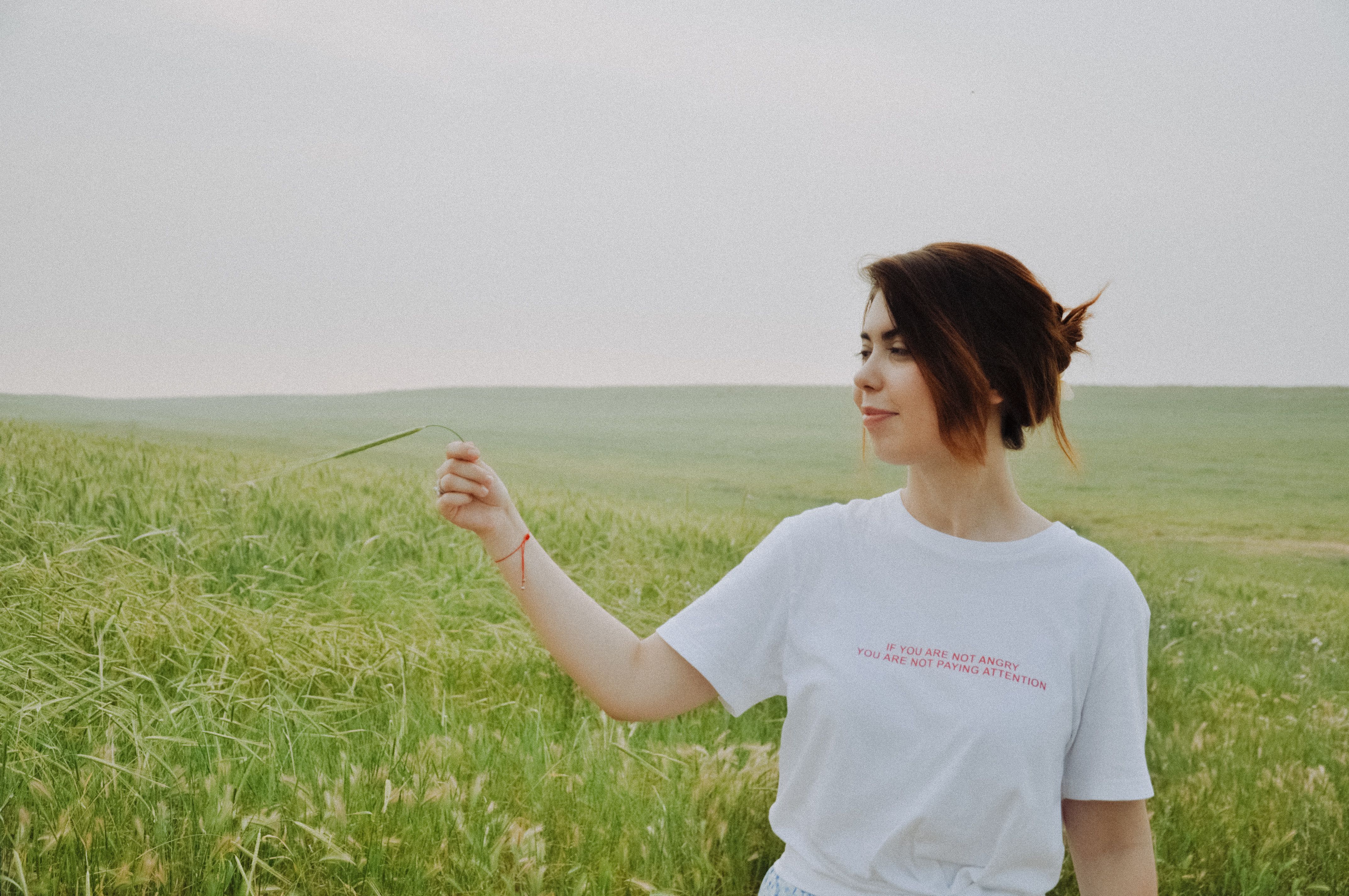 Woman in White Shirt Holding Grass in Green Field · Free Stock Photo