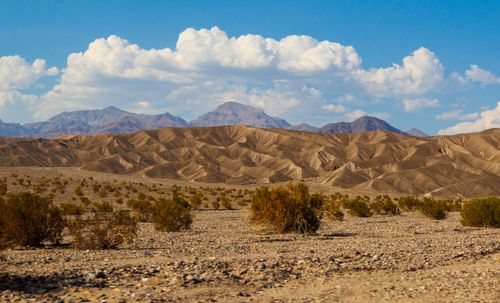 Free Breathtaking view of rugged desert terrain with mountains and clouds in Furnace Creek, California. Stock Photo