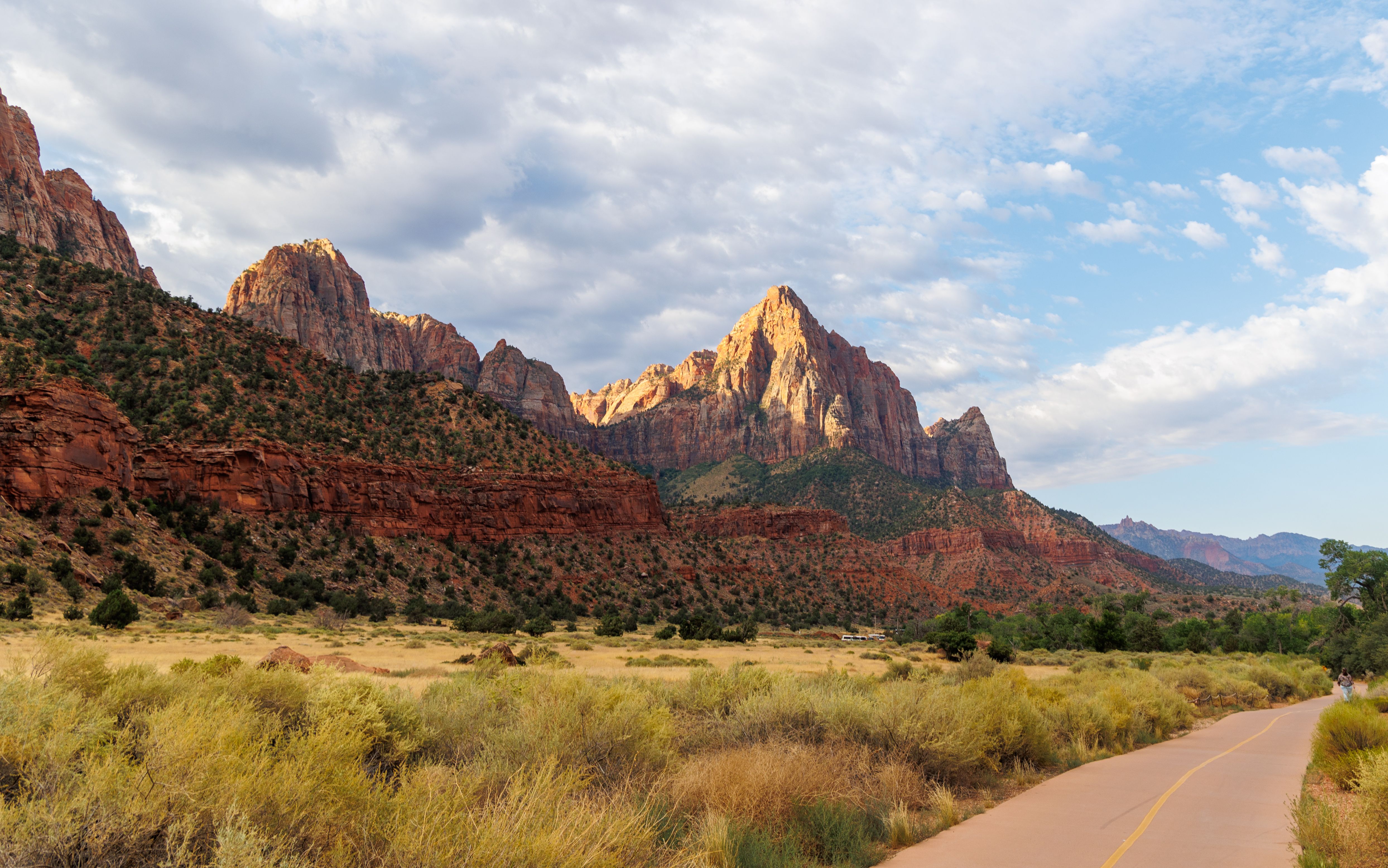 A dirt road leading to a mountain range with clouds · Free Stock Photo