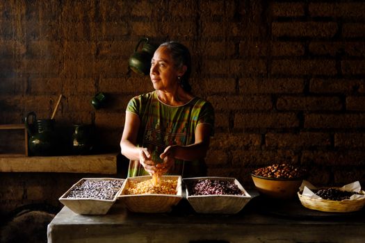 Woman preparing traditional meals with grains in Oaxaca, Mexico.