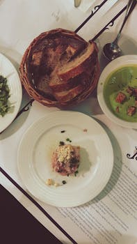 Tantalizing French meal featuring bread, soup, and more on a Parisian table.