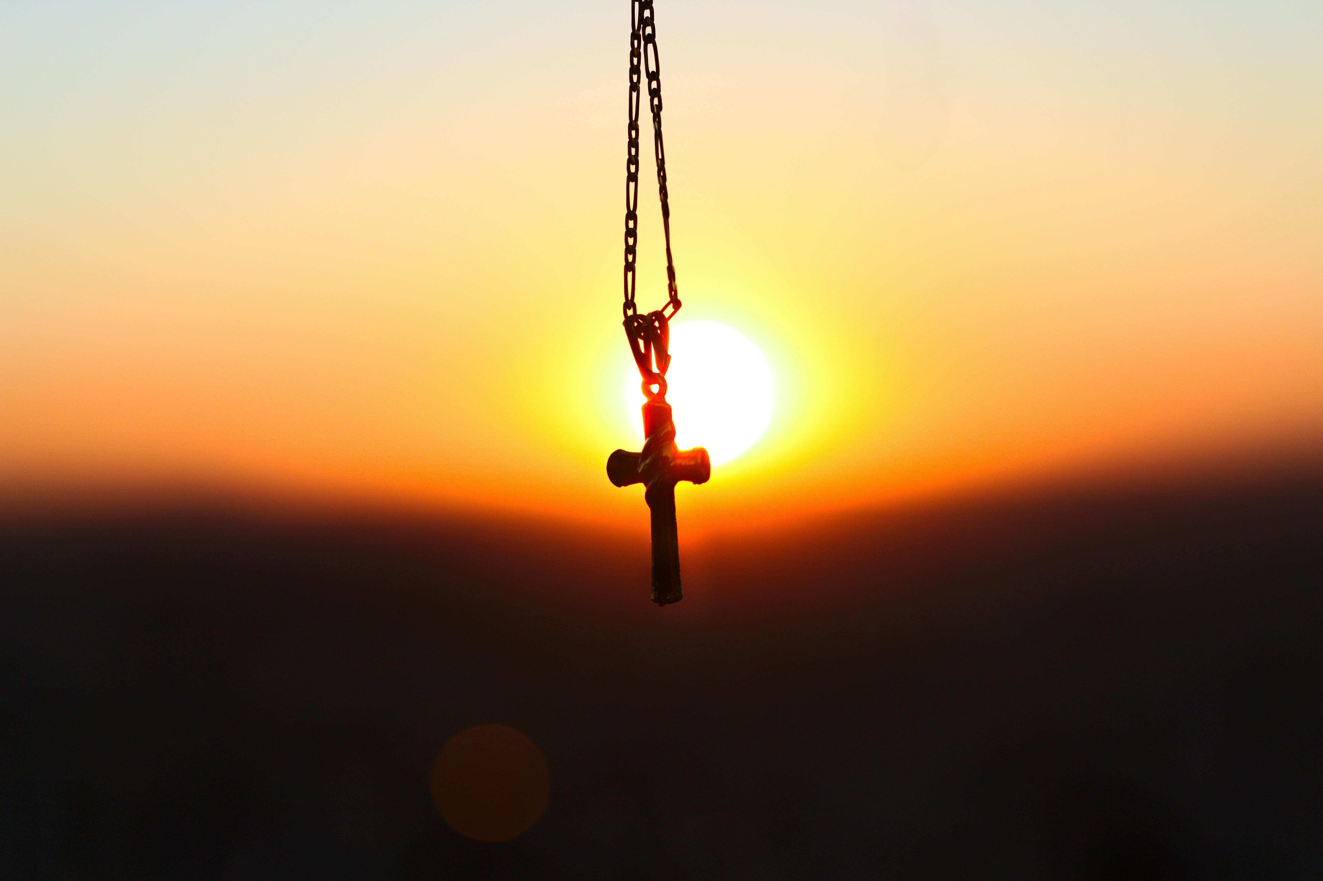 selective focus photography of cross pendant