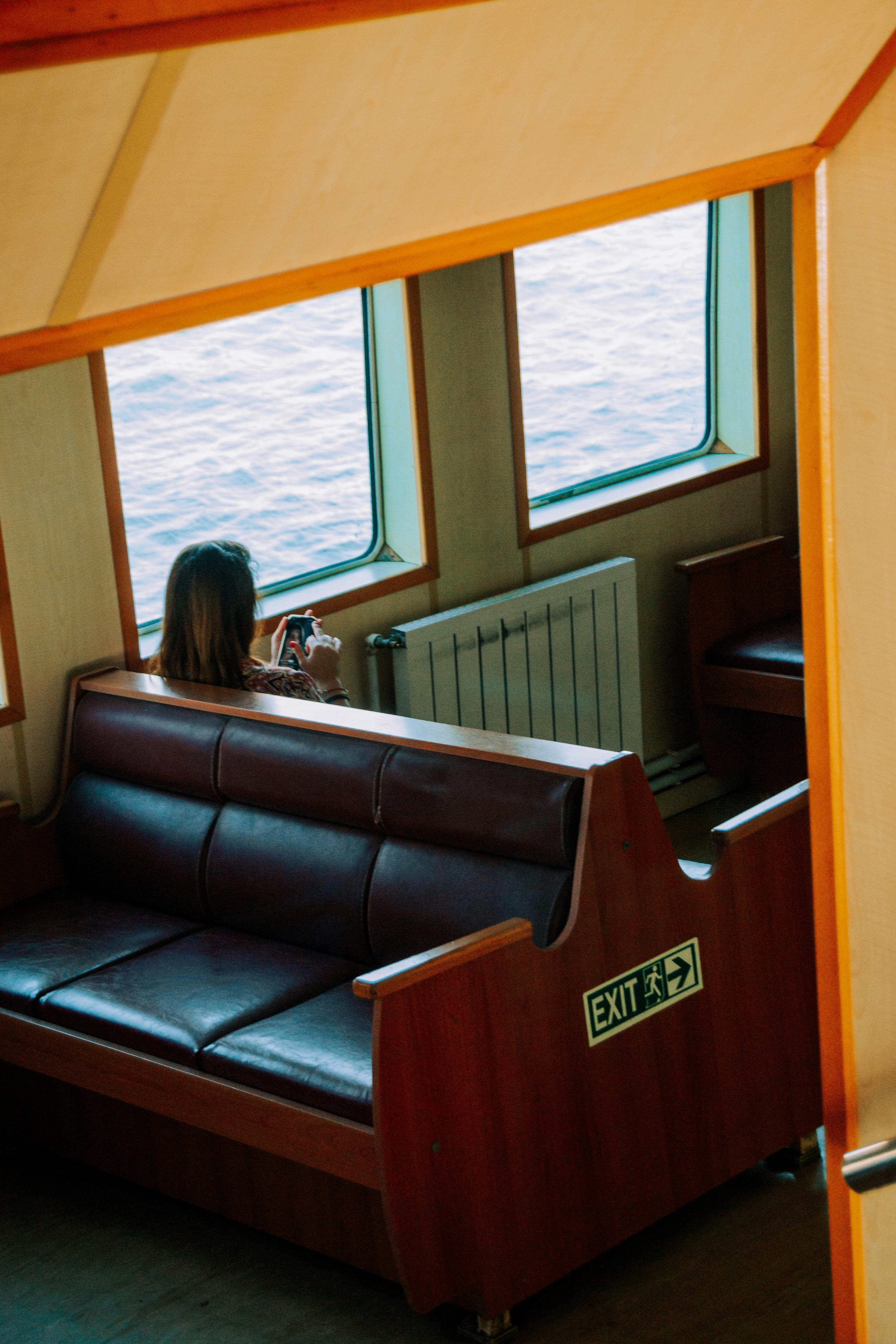 a woman sitting in a boat looking at a phone