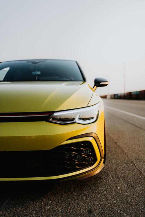 Free Front view of a yellow sports car on a road during the day, exuding speed and style. Stock Photo