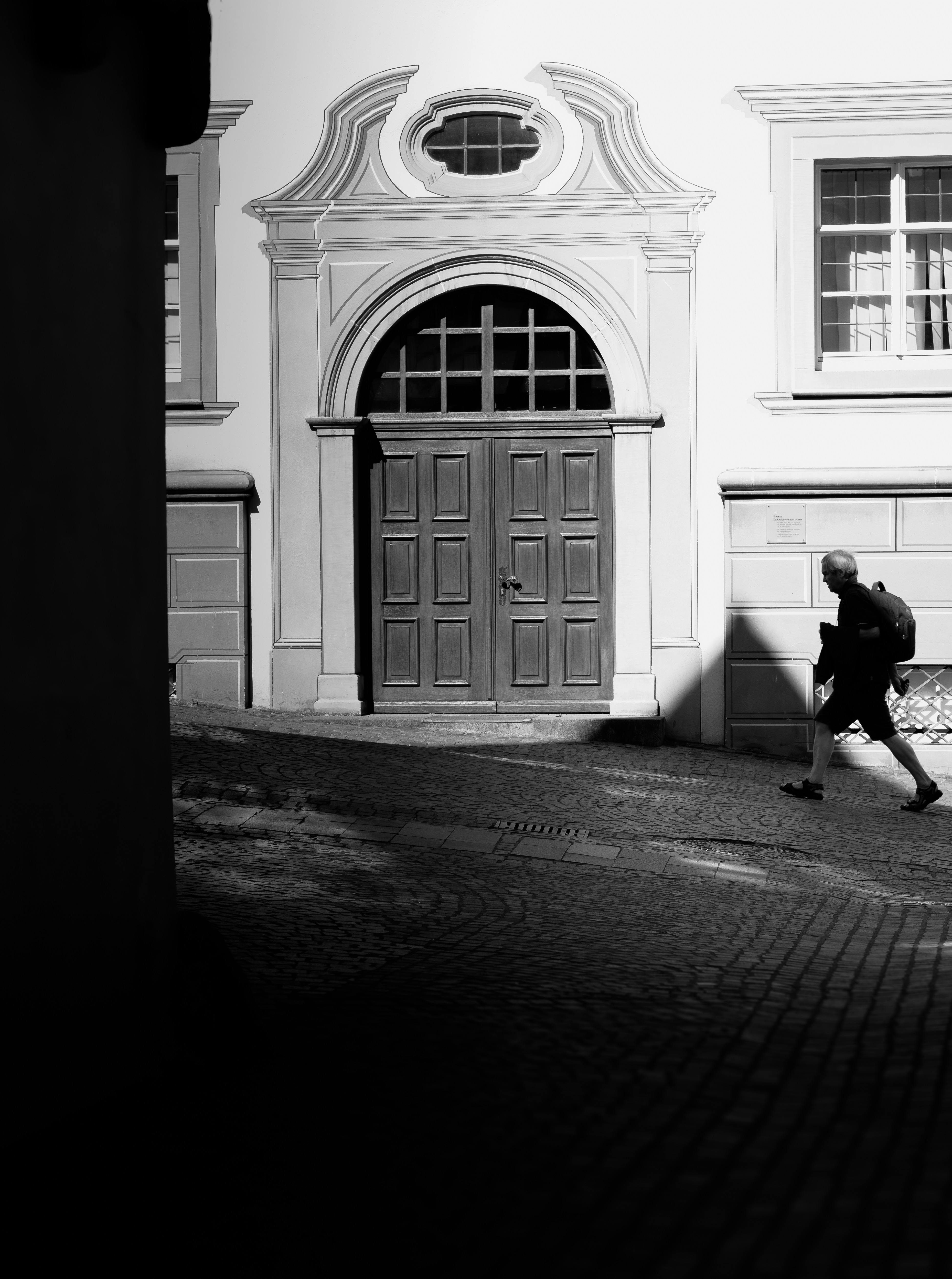 A person walking down a street in black and white