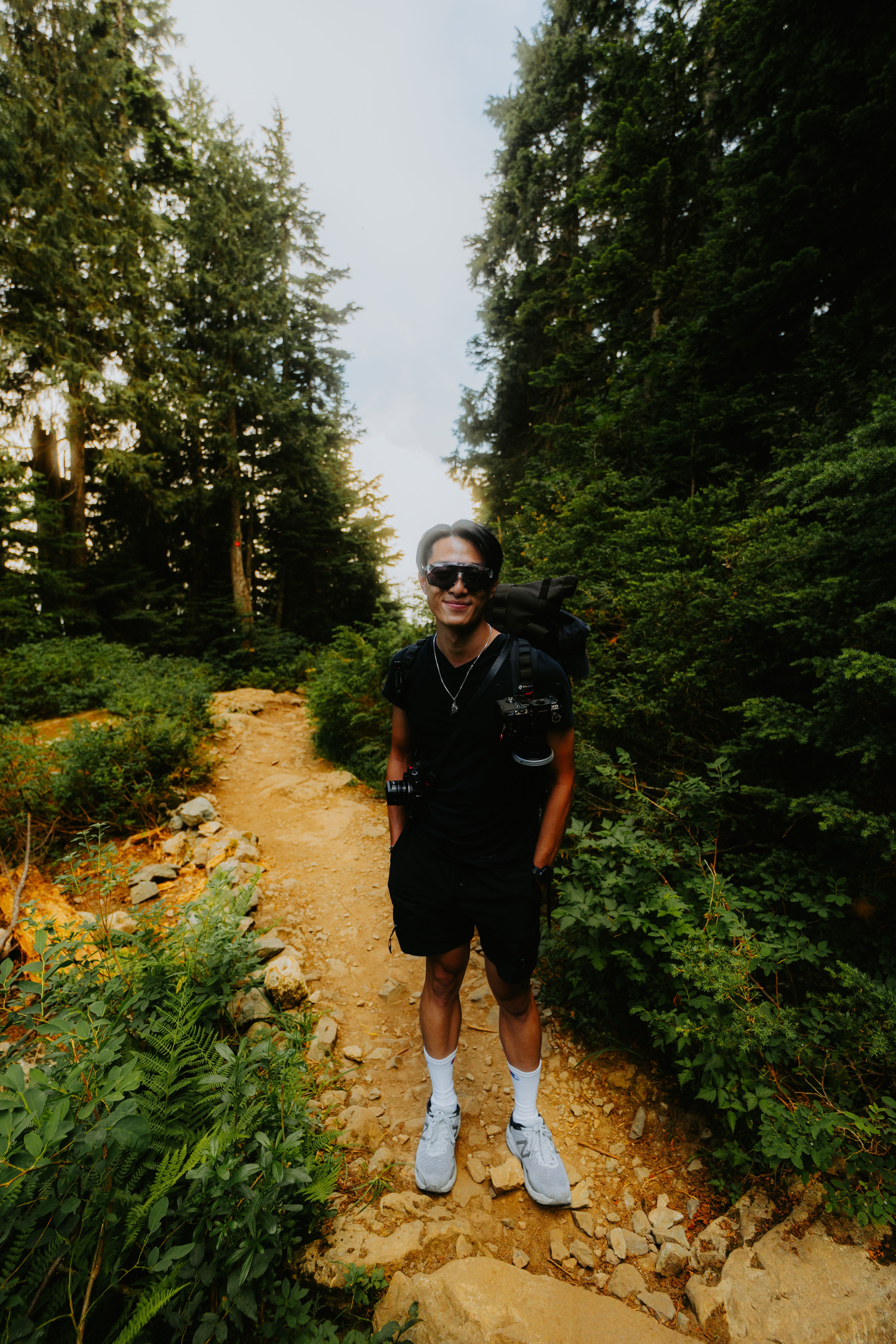 A man with a backpack is walking down a trail · Free Stock Photo