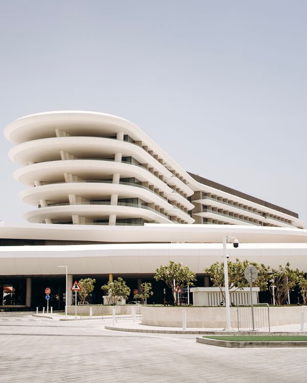 A large building with a curved roof and a white building · Free Stock Photo