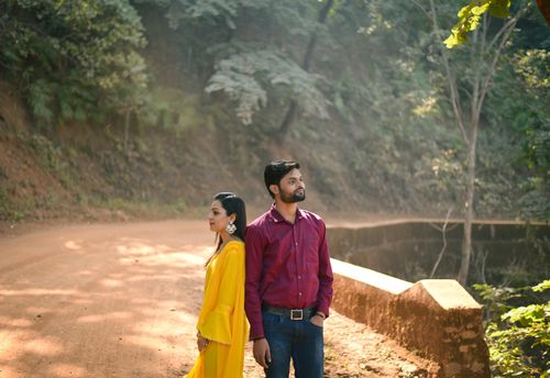 Free A couple standing outdoors in a serene forest setting with warm colors, capturing a reflective mood. Stock Photo