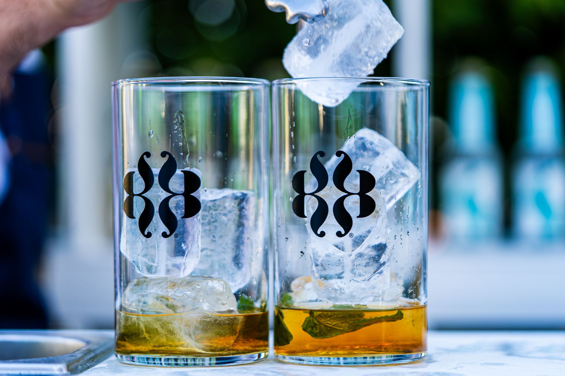 Close-up of refreshing cocktails with ice cubes and mint in glasses, perfect for a summer party.