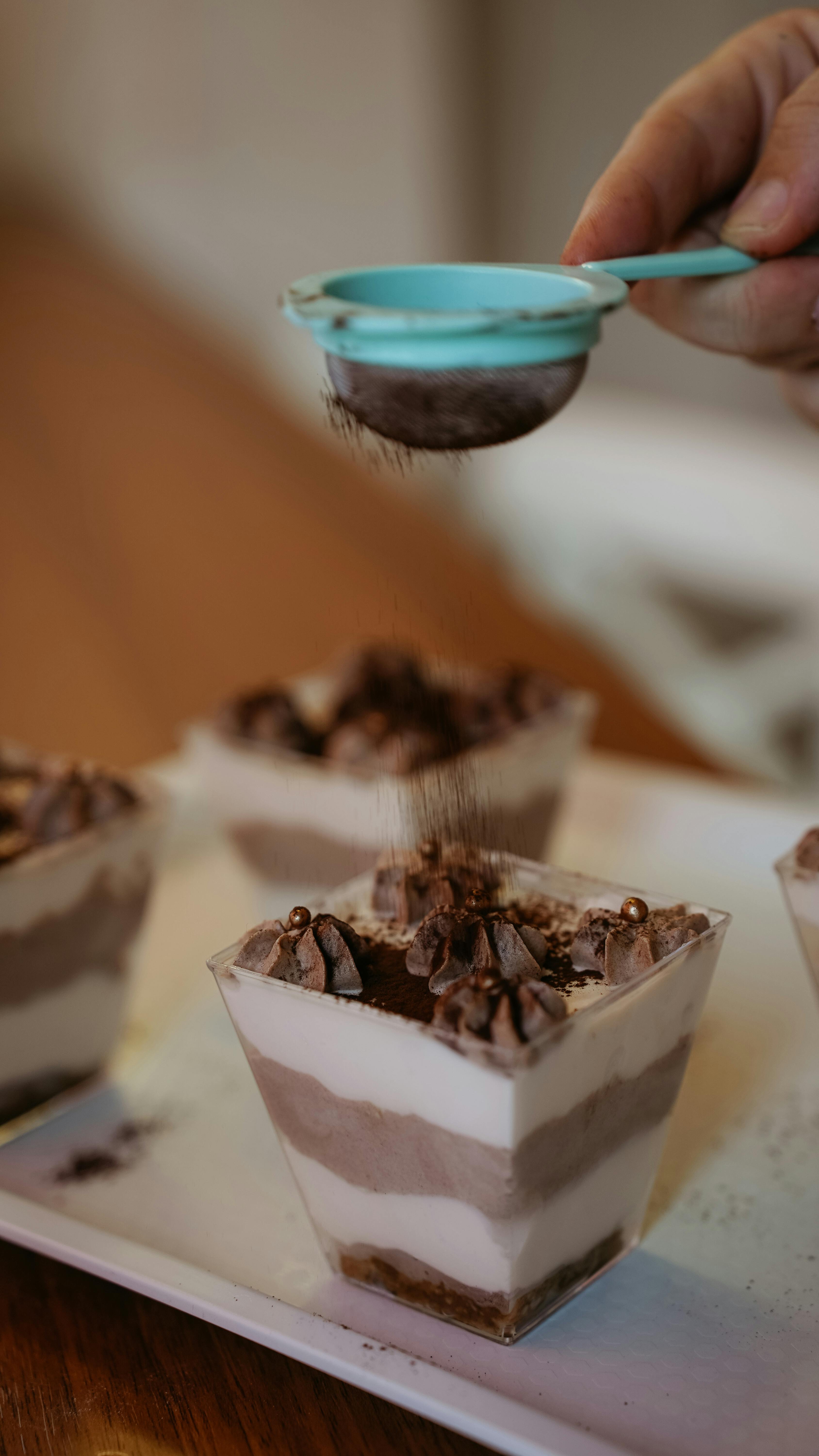 a person is pouring chocolate into a dessert