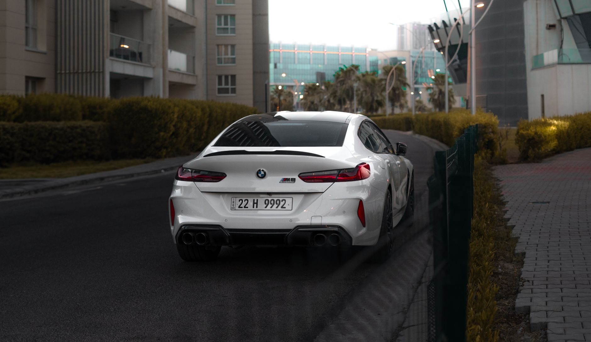 Luxury white BMW M8 car on a city street in Erbil, Iraq.