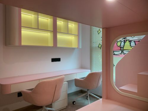 Free Stylish pink office space featuring sleek furniture and contemporary design with soft lighting. Stock Photo