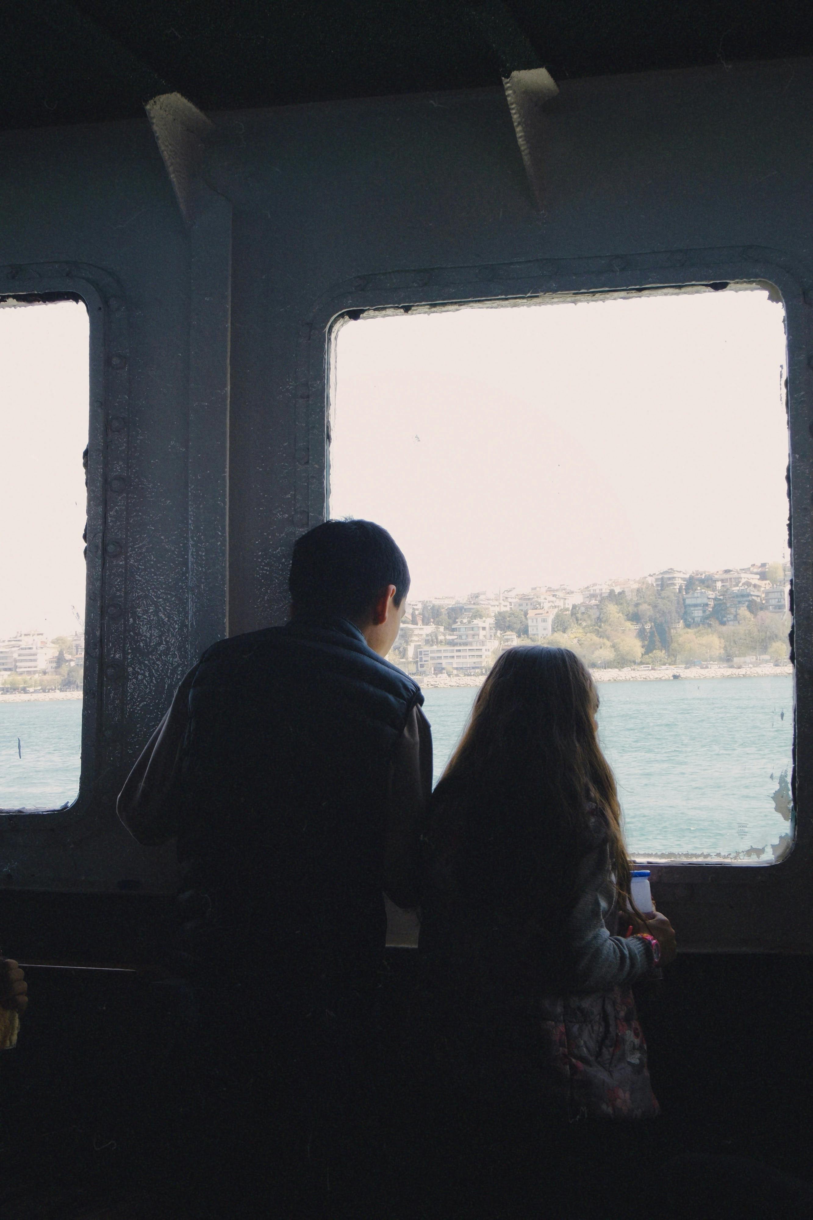 a couple looking out of a window at the sea