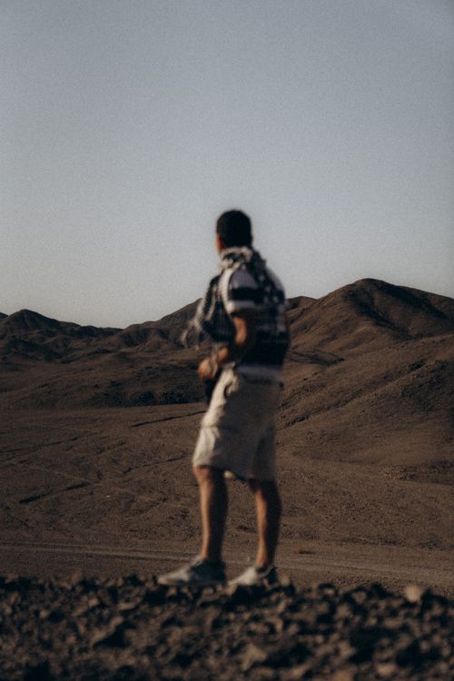 Free A man stands overlooking the rugged desert terrain of Marsa Alam, Egypt, captured during a sunny day. Stock Photo