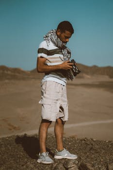A young man with a camera explores the desert landscape of Marsa Alam, Egypt, capturing the natural beauty.
