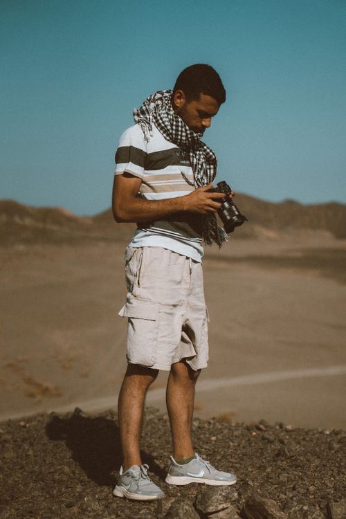 Free A young man with a camera explores the desert landscape of Marsa Alam, Egypt, capturing the natural beauty. Stock Photo