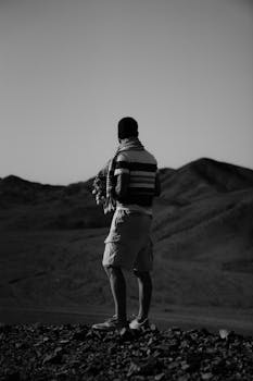 Black and white photo of a man standing in the desert of Marsa Alam, Egypt.