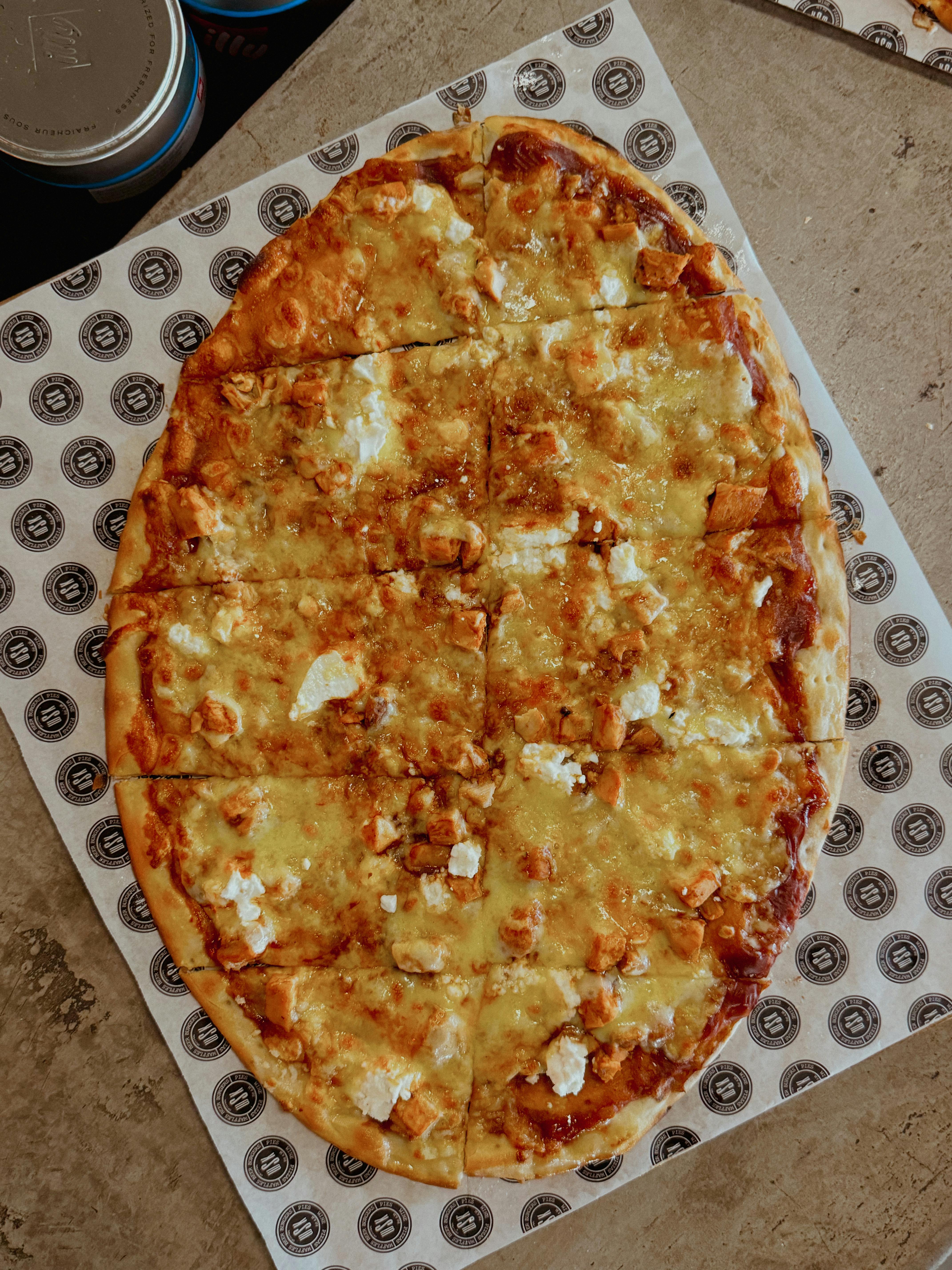 a pizza with cheese and other toppings on a paper