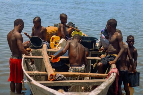 Free A group of fishermen working together on a wooden boat in a river, engaging in daily activities. Stock Photo