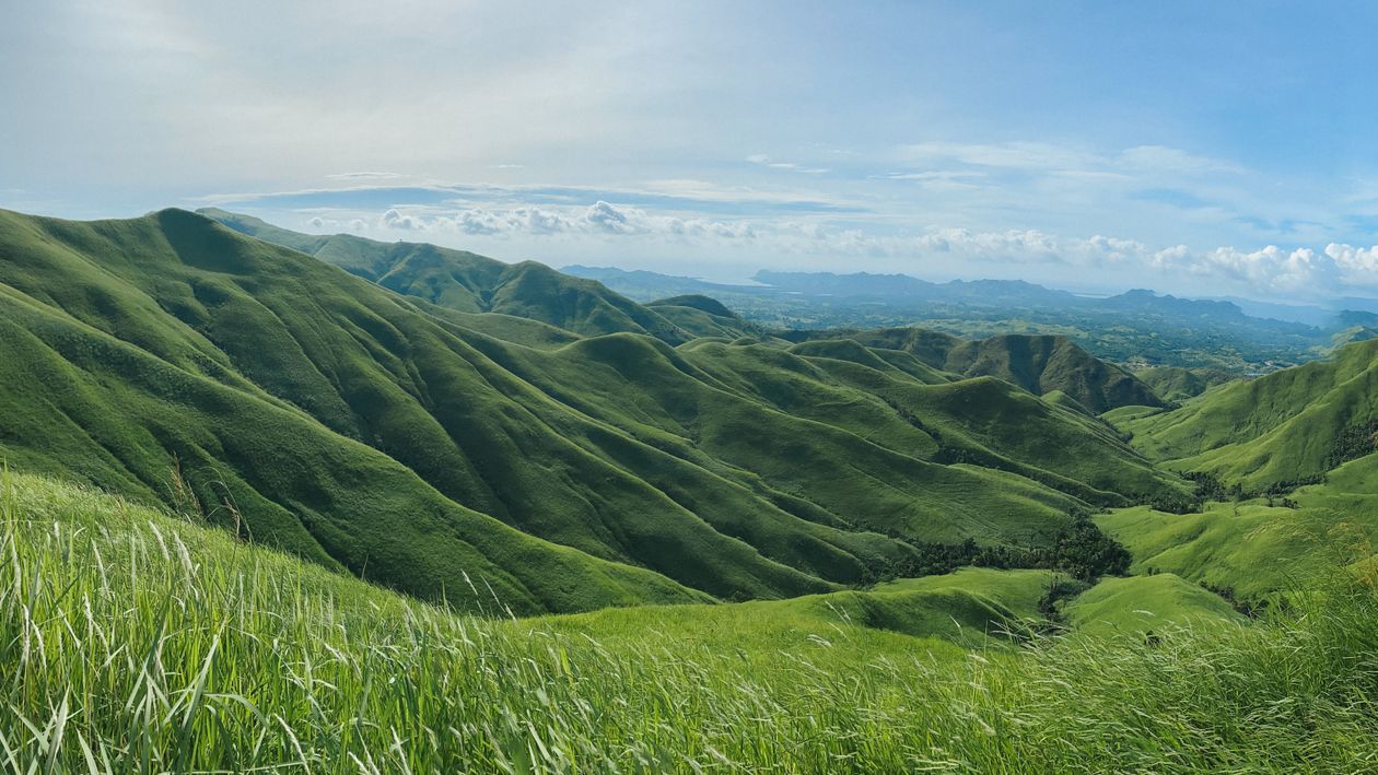 A panoramic view of green hills and grass · Free Stock Photo