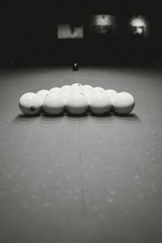 Artistic monochrome shot of pool balls neatly arranged on a billiard table, capturing the essence of the game.