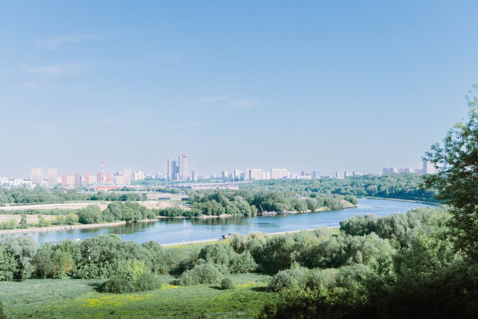 Breathtaking panoramic view of Moscow's skyline with a river and lush greenery under a clear sky.