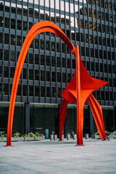 在现代建筑的城市环境中，充满活力的红色雕塑突出展示