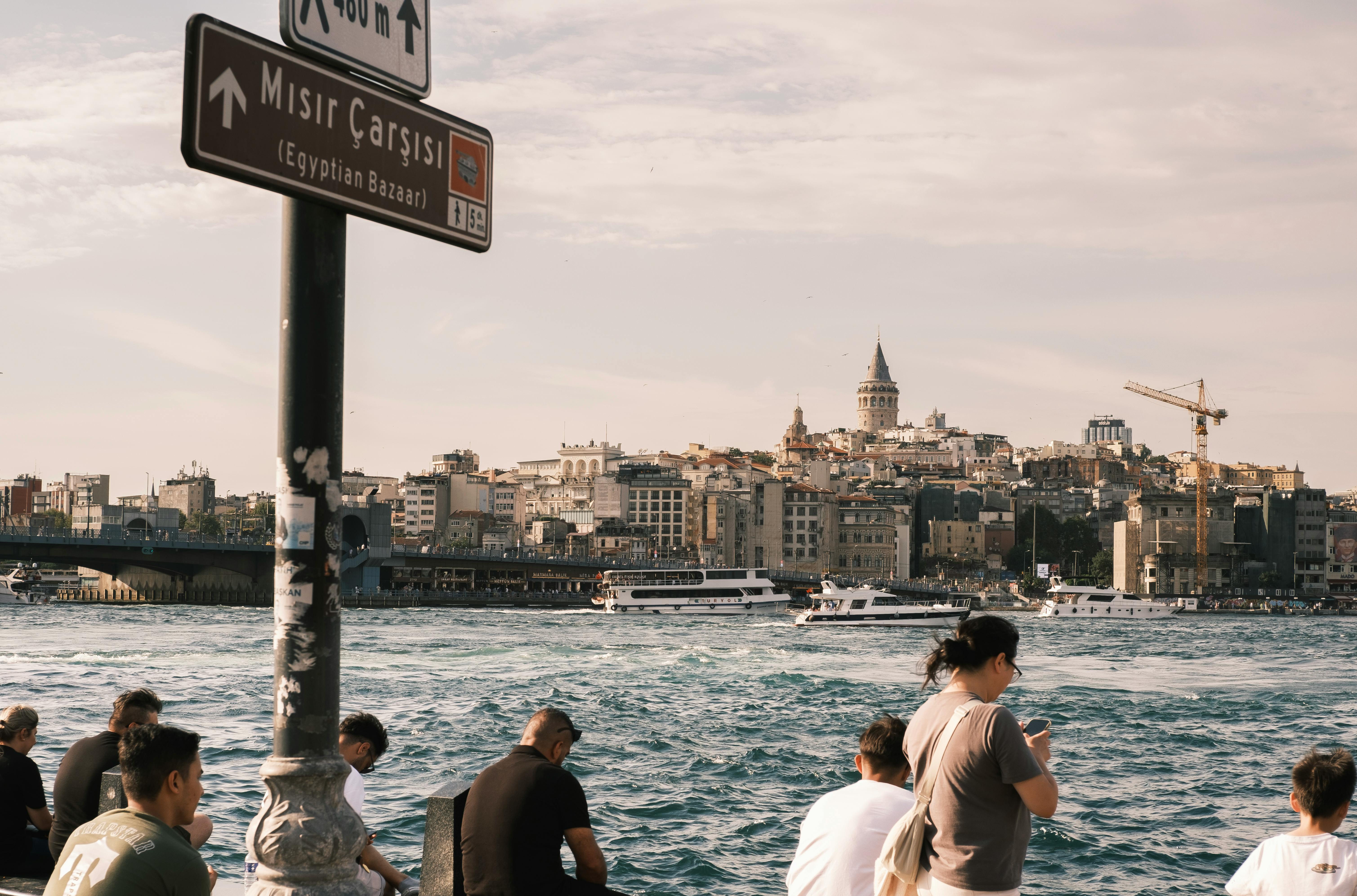 people are sitting on the edge of a body of water