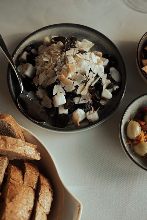 Free A close-up of a hearty breakfast with almond flakes, toast, and fruit. Stock Photo