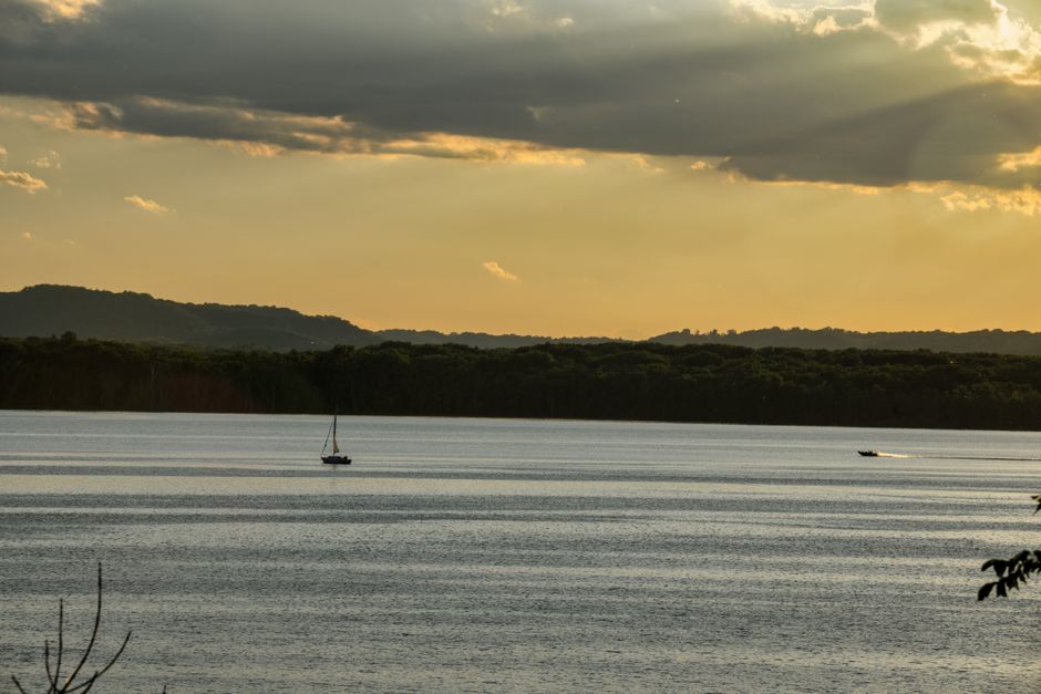 Peaceful sunset with boats on Lake Pepin in Stockholm, WI, reflecting golden hues.