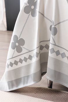 Elegant floral patterned tablecloth draped over a table in a modern home interior.