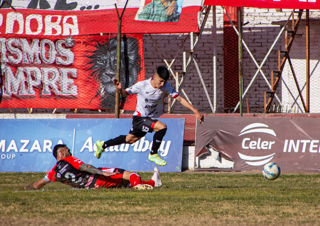 Soccer player braking hard and dropping low — the eccentric load of deceleration in sport