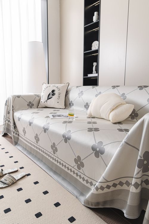 Free Contemporary living room featuring a stylish sofa cover with floral patterns and chic decor. Stock Photo
