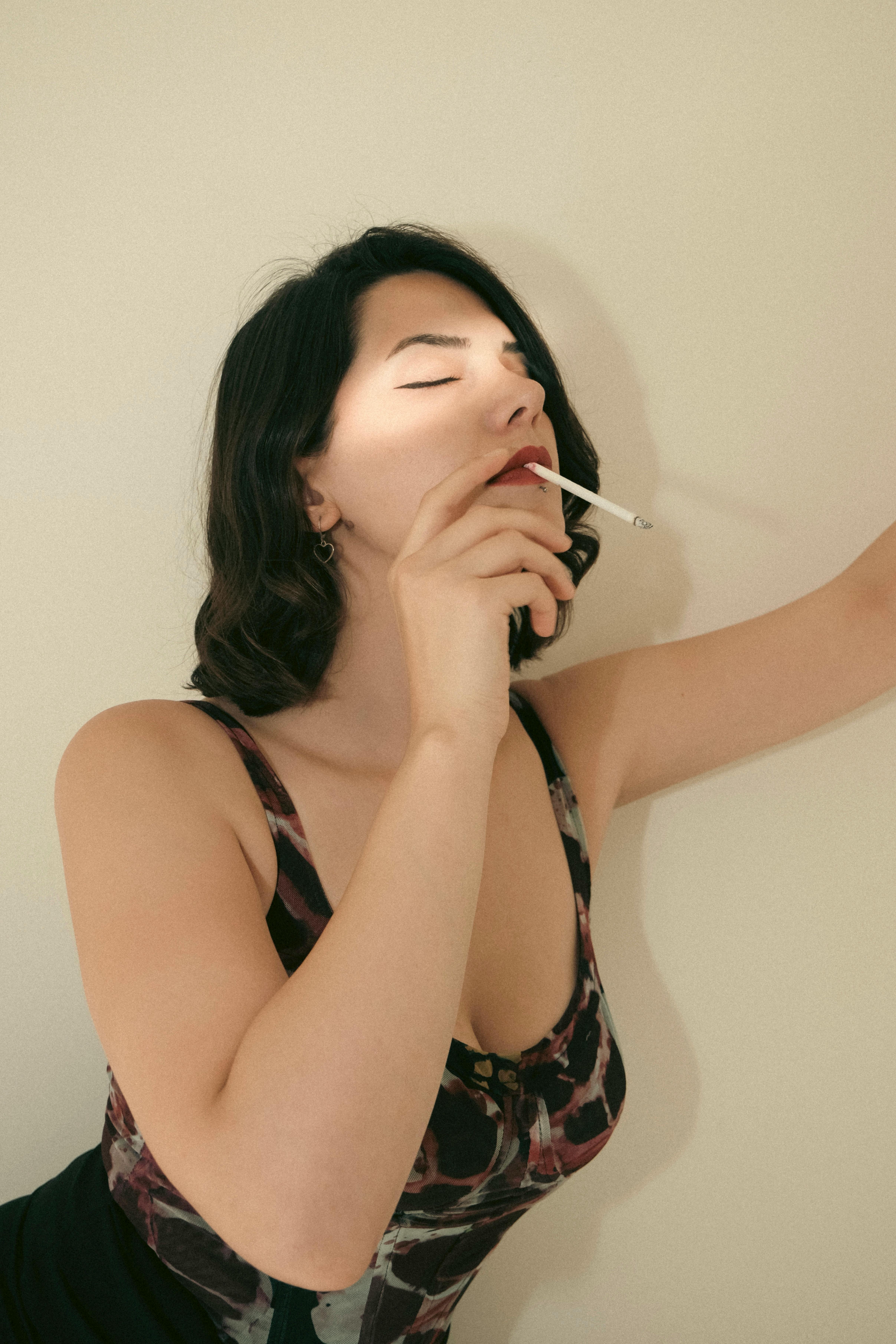 Stylized portrait of a woman smoking, captured with dramatic lighting and vintage tones.