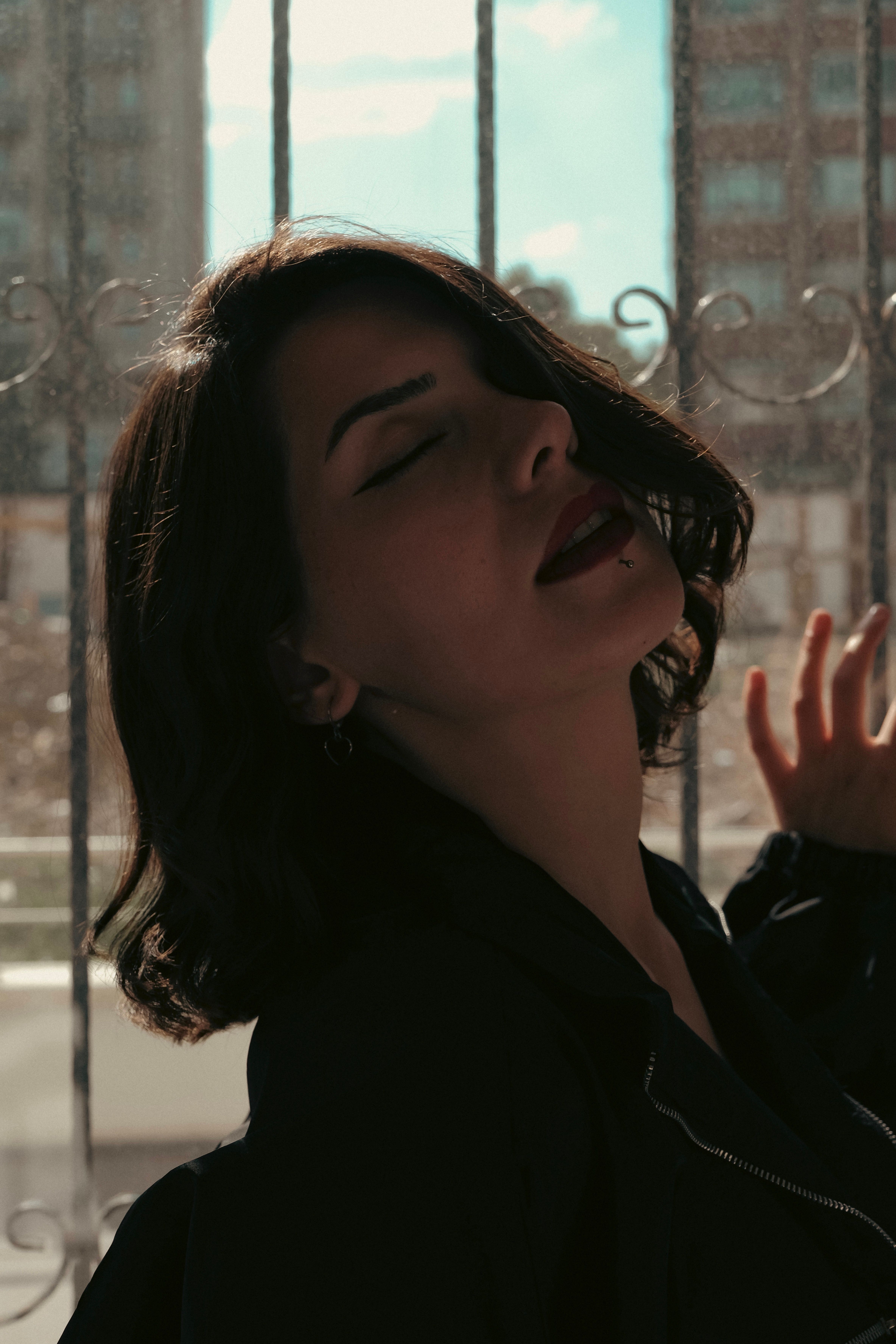 A woman with her eyes closed and her hands on her face · Free Stock Photo