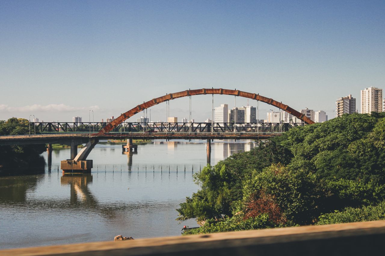 Scenic bridge view in Campos dos Goytacazes, Brazil with city skyline reflections.