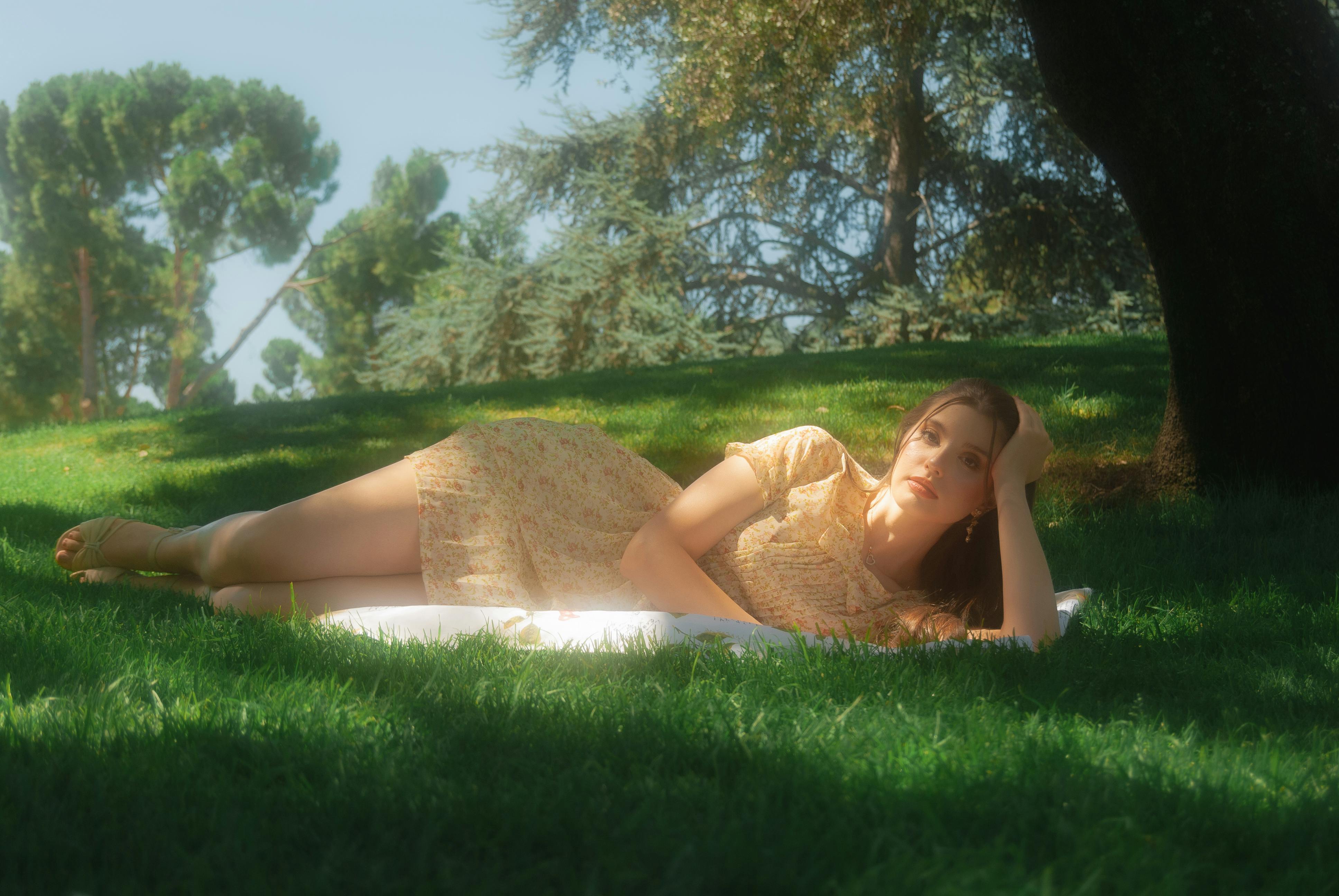 a woman laying on a blanket in the grass