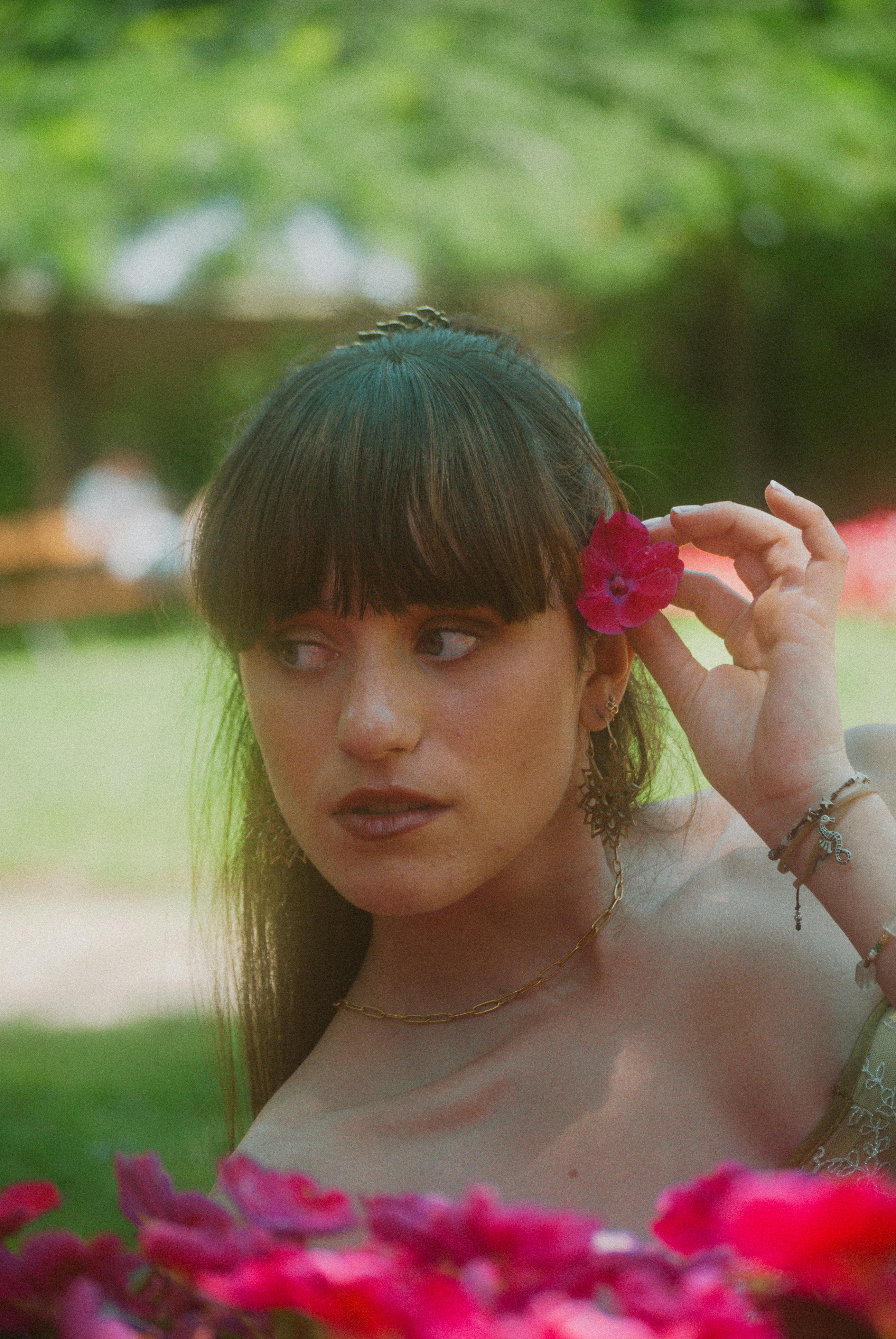 a woman with long hair is holding a flower