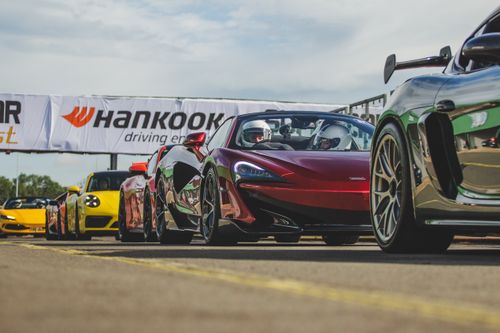 Free A lineup of high-performance sports cars ready for a racing event at a circuit. Stock Photo