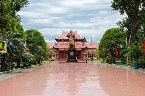 Free Majestic statue at the entrance of a traditional Asian temple surrounded by gardens. Stock Photo