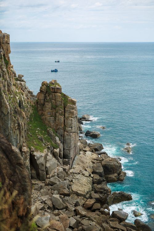 Free Scenic ocean view with rugged cliffs and clear water, perfect for a summer escape. Stock Photo
